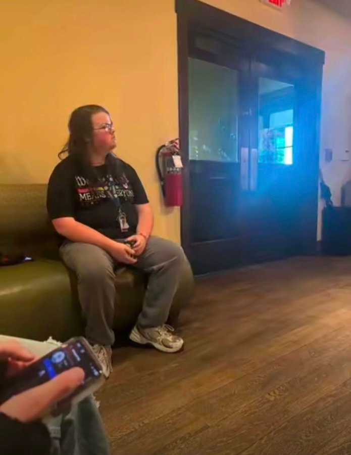 Nova sitting in a green couch in a waiting area.