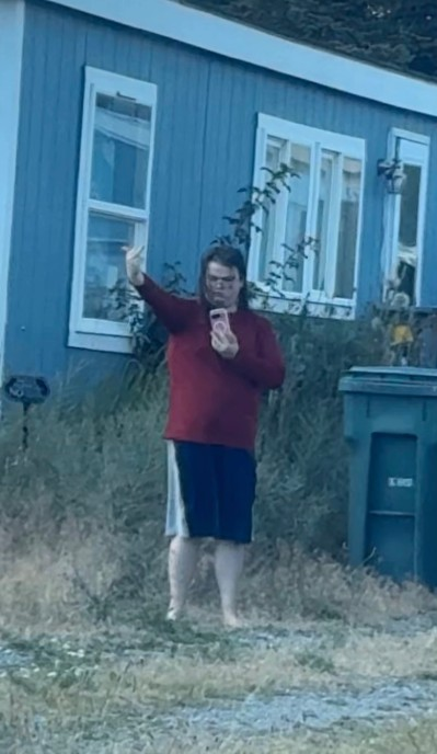 Gabriel Gage recording on his phone and giving the middle finger.